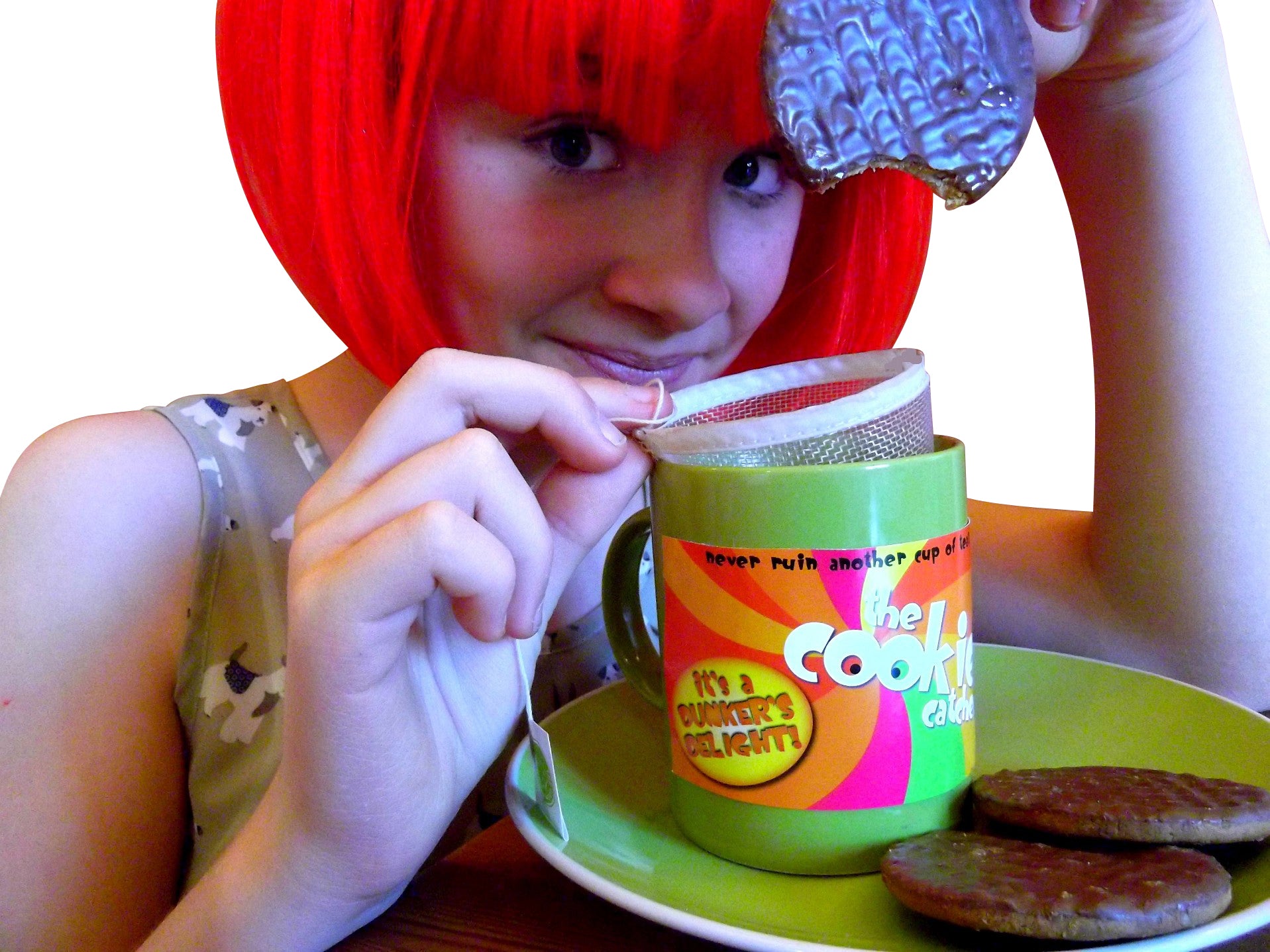 Person dunking biscuit in tea with Cookie Catcher mesh device preventing soggy crumbs